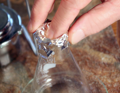 Push foil into mouth of flask