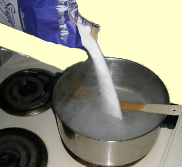 pouring sugar into pot of hot water