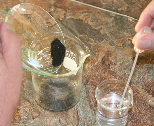 transfer black sand to beaker